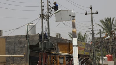 Ministry of Electricity workers maintaining the electricity transmission network in Basra. One of the contracts GE signed with Iraq's Ministry of Electricity is a $727m agreement to reinforce the country's transmission network and its interconnection with Jordan's grid. AP Photo