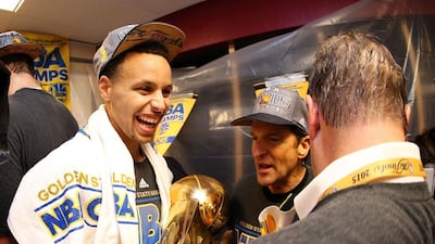 Stephen Curry #30 of the Golden State Warriors celebrates with team owners Peter Guber and Joe Lacob and the Larry O’Brien NBA Championship Trophy in the locker room after defeating the Cleveland Cavaliers 105 to 97 to win Game Six of the 2015 NBA Finals at Quicken Loans Arena on June 16, 2015 in Cleveland, Ohio. Ezra Shaw/Getty Images