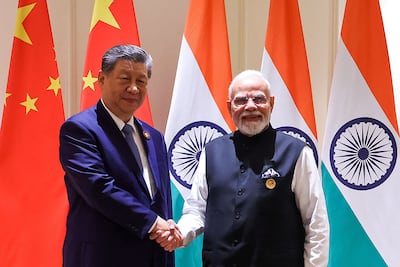 Xi Jinping, left, and Narendra Modi shake hands as the Brics Summit draws to a close. AFP