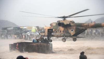 An Afghan military helicopter rescues people from an overturned truck in a flooded area of Arghandab district in Kandahar province. AFP