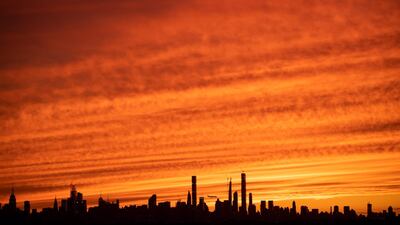 A plane flies over Manhattan's skyline at sunset in New York City. AFP