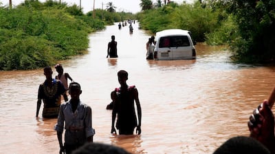 Sudanese people walk a flooded road in Wad Ramli village on the eastern banks of the Nile river. AFP