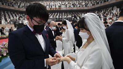 Couples wearing protective face masks attend a mass wedding ceremony organised by the Unification Church at Cheongshim Peace World Center in Gapyeong. AFP