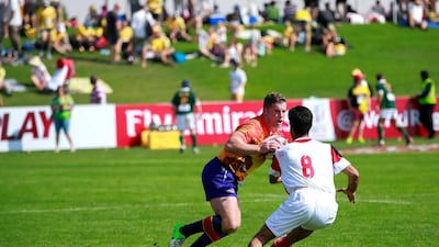Christina Noble Children’s Foundation (orange) v Shahdary (white): Mel Dean (center) breaks through the Shahdary Tabriz defense during Day 1 of the Emirates Airlines Dubai Rugby Sevens at The Sevens in Dubai on Thursday. Victor Besa for The National