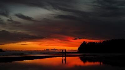 People walk along the shore in Santa Catalina, Panama. AP