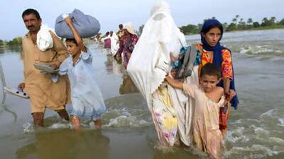 Flood victims trudge along a major road that was inundated by floodwaters in the Punjab region on Friday.
