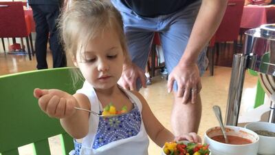 Calla Johnson drops tri-colored bell peppers on her bespoke pizza . Courtesy Stacie Overton Johnson