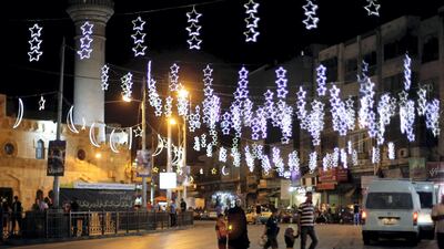 Pedestrians walk along a street decorated for Ramadan in Amman. Reuters