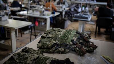 A pile of freshly made military vests sit on a table in a makeshift factory in Mykolaiv.