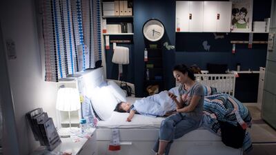 A mother with her child escaping the summer heat by relaxing on a sofa in an Ikea store in downtown Shanghai. AFP / Johannes Eisele