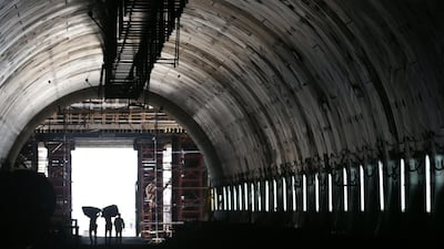 Labourers walk near the entrance to one of the new tunnels. EPA