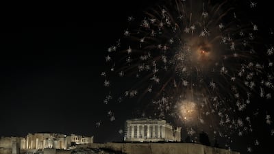 Fireworks illuminate the Athenian sky as the temple of Parthenon sits atop the Acropolis hill during the New Year celebrations on January 1, 2023. EPA
