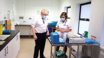 UK Prime Minister Boris Johnson speaks to Jane Hosea, a pharmacy technician, during a visit to a vaccination centre in Northampton, England, on Thursday, January 6, 2022. Getty