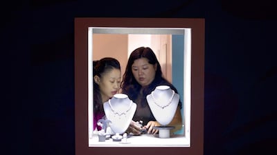 Two vendors adjust a display of jewels at the Hong Kong Jewellery and Gem Fair. Alex Ogle / AFP