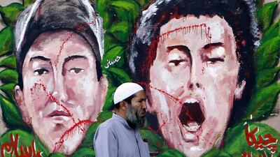 An anti-Morsi protester walks past graffiti depicting two activists who died recently, at Tahrir Square in Cairo. Mohamed Abd El Ghany / Reuters