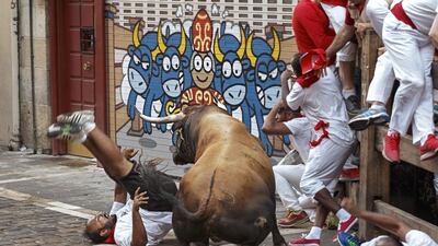 A reveler is gored by a Cebada Gago’s ranch fighting bull during the running of the bulls in Pamplona, Spain. A hospital official said five people were gored by fighting bulls in a hair-raising second running of the bulls at Pamplona’s San Fermin festival. Daniel Ochoa de Olza / AP