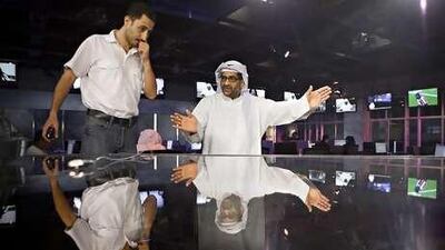 Mohammed Alnuwais, right, and Nshat Kteesh discuss the telethon in Abu Dhabi TV's newsroom.