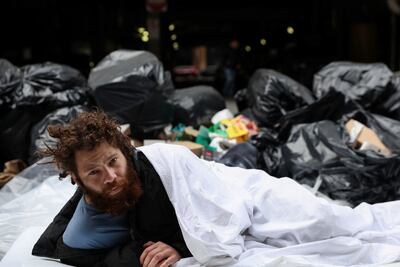 Alex, 27, who said he has been homeless for 8 years, lays on a sidewalk outside Port Authority bus station in the Midtown area of New York City, on May 3. Reuters
