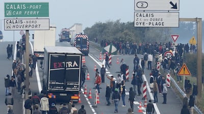 Migrants gather near lorries that head towards the ferry terminal in Calais, France. Reuters
