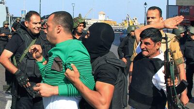 Security forces arrest a pro-Morsi protester during clashes in Alexandria, Egypt. Amr Nabil / AP Photo