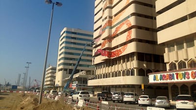 The view down Bank Street as street artist eL Seed paints the words of a local poet on an abandoned building. Courtesy of Anna Seaman / The National