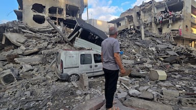 A man searches the debris of a building in the southern Lebanese coastal city of Tyre on May 23, 2026, after an Israeli attack. Two buildings in and around Tyre were bombed overnight on May 22 into May 23, after the Israeli military threatened residents to leave. AFP