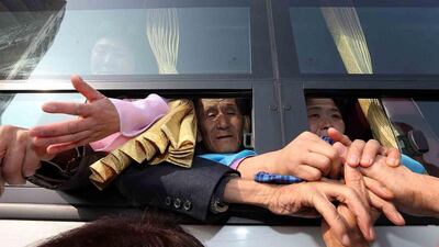 North and South Korean families hold hands at a bus stop on February 25, 2014, as they leave the inter-Korean family reunion meeting at Mount Kumgang resort, North Korea. Hundreds of South Koreans bade farewell to their long-lost relatives from North Korea after their first contact since the 1950-53 Korean War. Lee Ji-Eun / EPA