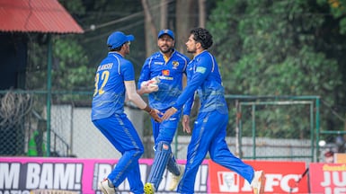 Ajay Kumar, right, celebrates one of his six wickets for the UAE against Oman. Photo: Cricket Association of Nepal