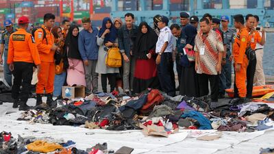 In this Oct. 31, 2018, file photo, relatives of passengers of a crashed Lion Air jet check belongings retrieved from the ocean in Jakarta, Indonesia. AP