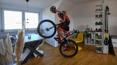 Ben Zwiehoff, the German national team's racing cyclist in the mountain bike cross-country discipline works on his balance on his bike in his flat, in Essen, western Germany. AFP