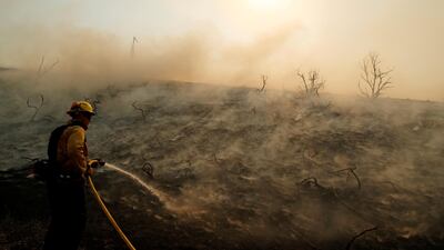 A firefighter uses a hose as the Silverado Fire approaches, near Irvine, California, U.S. October 26, 2020. REUTERS
