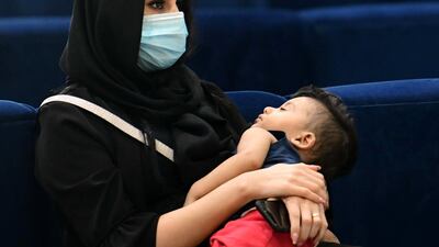 An Iraqi woman wears a protective mask as she waits to board a flight at Baghdad international Airport. EPA