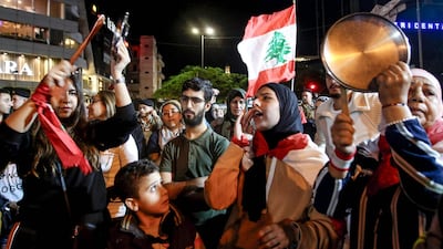 Protesters chant slogans, bang pot covers, and wave a Lebanese national flag during an anti-government demonstration in the southern Lebanese city of Sidon. AFP