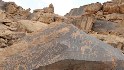 Rock art in the Al Hail Region shows inscriptions and camels on a rock at the base of Jebel Umm Sinman in Saudi Arabia