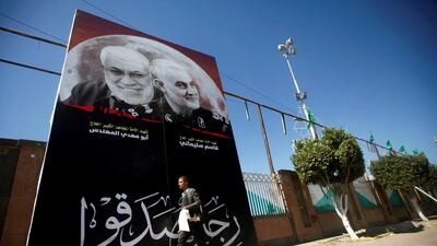 A man passes next to a billboard with posters of Iranian Major-General Qassem Suleimani, head of the Quds Force, and Iraqi militia commander Abu Mahdi al-Muhandis, who were killed in an air strike at Baghdad airport, in Sanaa. Reuters