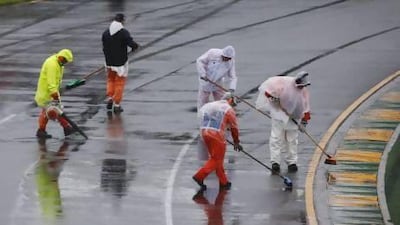 Marshals remove excess water on the track before the qualifying session of the Australian F1 Grand Prix at the Albert Park circuit. Daniel Munoz / Reuters