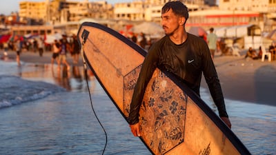 Palestinian surfer Hussein Abu Assi, 23, takes his surfboard out into the Mediterranean sea off a beach in Gaza City. AFP