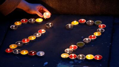 A woman places candles for each of the dead as a tribute in St Anne's Square. REUTERS/Andrew Yates