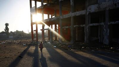 A Palestinian girl walks past buildings destroyed during the 50-day war between Israel and Hamas militants in the northern Gaza Strip. Mohammed Abed / AFP