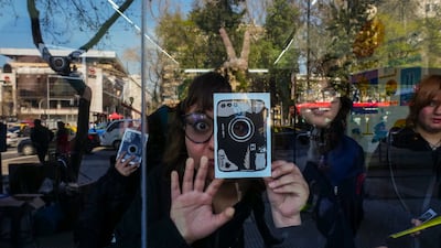 A student holds cardboard mock-ups of cameras while visiting an exhibit at the Gabriela Mistral gallery in Santiago, Chile. AP