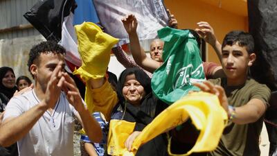 Palestinian protesters wave the flags of Palestinian political movements, Fatah (yellow) and Hamas (green) as they chant slogans in support of the national reconciliation and the announcement of the formation of a national unity government between the two factions. Said Khatib/ AFP Photo