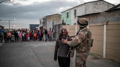 South African National Defence Forces soldier directs a woman during a joint police operation in Cape Flats. AFP