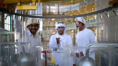 Students Khalifa Al Zaabi, Ali Al Kaabi, and Naser Al Shehhi look at a model nuclear reactor that is on display at Abu Dhabi Polytechnic. Ravindranath K / The National