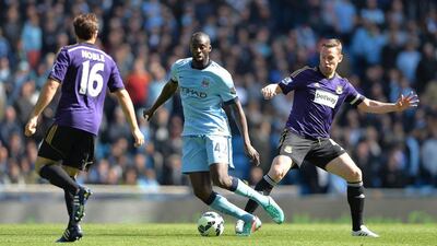 Yaya Toure of Manchester City dribbles between West Ham United defenders during his side's Premier League win on Sunday. Peter Powell / EPA / April 19, 2015