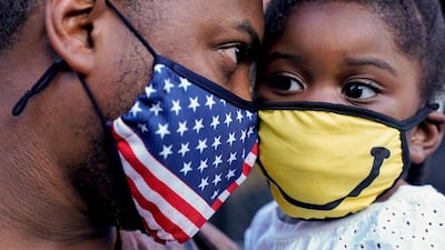 Schevon Salmon, of Washington, left, celebrates with his 2-year-old daughter Nyomi Salmon, President-elect Joe Biden's win over President Donald Trump, in Washington. AP Photo