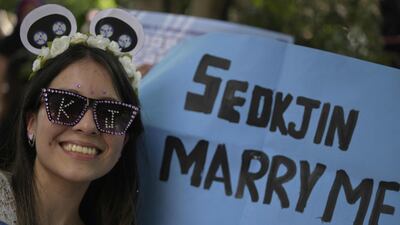 A fan has a sign asking Jin to marry her.