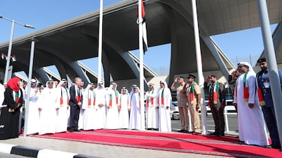 Sheikh Ahmed bin Saeed Al Maktoum (C), chairman and chief executive of Emirates Airline and Group, raises the UAE flag in front of Dubai International Airport. EPA