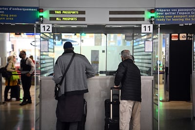 Travellers shows their documents to a border police officer at Roissy Charles-de-Gaulle international airport. Christophe Archambault / AFP