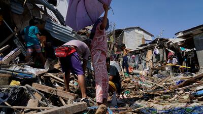 Residents salvage parts of their damaged homes in Talisay. AP