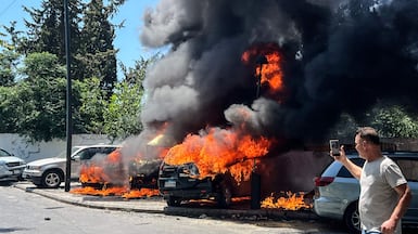 Cars burn after being hit in an Israeli air strike in Sidon, southern Lebanon. AFP